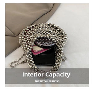 Detail view showing internal capacity of silver beaded bag with phone and cosmetics