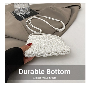 Detail of white woven crossbody bag with pleated texture and stylish shoulder strap
