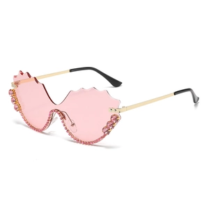 Lunettes de soleil sans monture rose avec bords ondulés et détails en strass