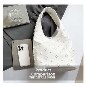 Detailed view of white hobo bag with floral applique texture and leather finish