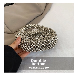 Detailed close-up of handmade silver multi-faceted bead weaving on a mini evening bag