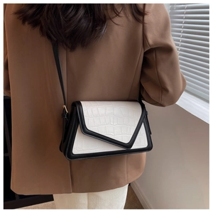 Detail of contrast stitch shoulder bag with crocodile texture on a brown blazer outfit