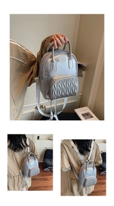 Detailed views of silver mini backpack with wavy pleats and adjustable straps
