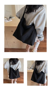 Vista dettagliata della capiente borsa tote in tela nera con trama resistente e design minimal