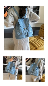 Detail of light blue denim backpack with brown leather straps and multi-pocket design