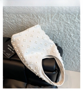 Detail view of white lychee textured hobo bag with unique 3D petal rivet decorations