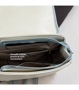 Detail view of the bag interior showing a smooth silver zipper and printed lining