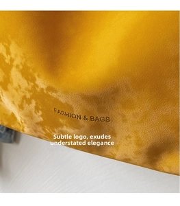 Detail of yellow lychee textured leather tote bag with FASHION & BAGS logo embossing