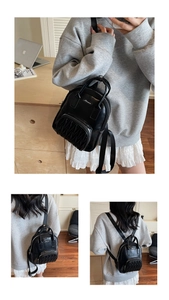 Close-up of black quilted mini backpack with stylish gathered pleat front pocket design