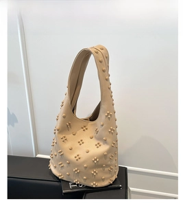Detail of khaki hobo bag with floral stud patterns and soft lychee leather texture