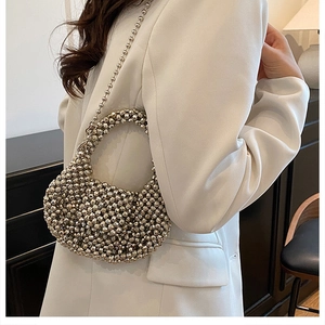 Detail of silver beaded hobo bag with metallic pearls and slender chain shoulder strap