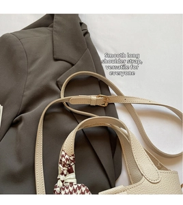 Detail of cream bucket bag with lychee texture and red houndstooth silk scarf