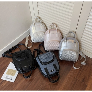 Detailed display of mini backpacks in silver, pink, white, black, and denim textures