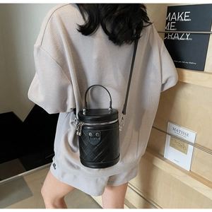 Detailansicht der schwarzen Zylindertasche mit klassischer Rautensteppung und Handgriff