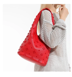 Detail of red Hobo shoulder bag with 3D floral rivets and litchi grain texture