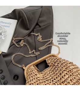 Détail de la texture d'un sac en paille tressée avec bandoulière en chaîne dorée