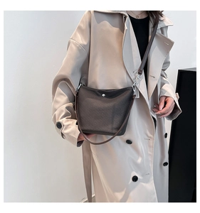 Détail du sac seau marron foncé avec texture tressée et boucle métallique argentée