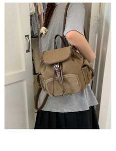 Side view of large capacity denim backpack with leather trim on model for travel