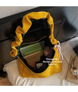 Top-down view of a spacious yellow pleated tote bag showing large interior storage capacity