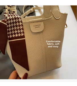 Detail of lychee pattern leather bucket bag with houndstooth silk scarf handle decoration