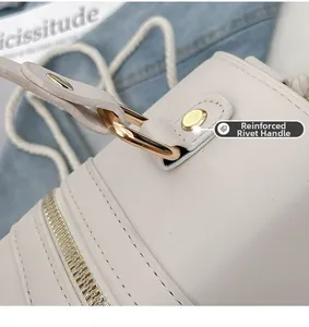 Detail of straw bag with golden metal ring, reinforced rivets and zipper closure