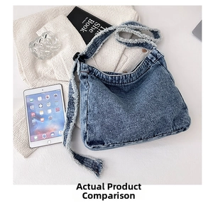 Gros plan du sac hobo en jean bleu avec bords effilochés et boucle de réglage en noir