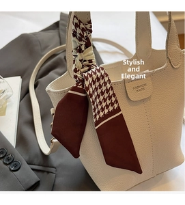 Detailed macro view of white pebble leather bucket bag with houndstooth silk scarf handle