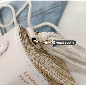 Detail view of the golden metal buckle on a woven straw bag with a rope strap