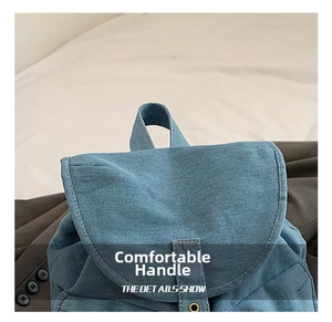 Detailed close-up of the denim backpack handle showing high-quality fabric texture