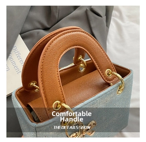 Detail of light blue denim handbag with rhinestones and brown leather handle