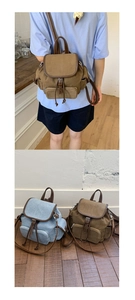 Detail view of small canvas backpacks with leather straps in brown and light blue colors