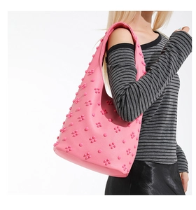 Close-up of pink hobo tote bag with 3D floral texture carried by a model