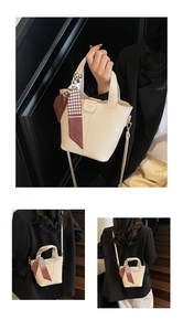 Dettaglio borsa a secchiello crema in pelle martellata con foulard pied-de-poule