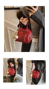 Detail of red baseball-themed pillow bag with white stitching and mini charm pendant