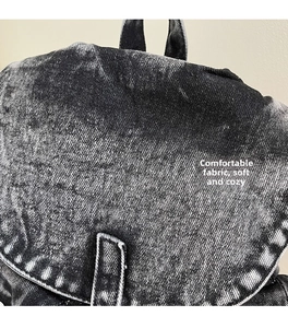 Macro de la tela vaquera negra lavada al ácido de la mochila con textura vintage y costura