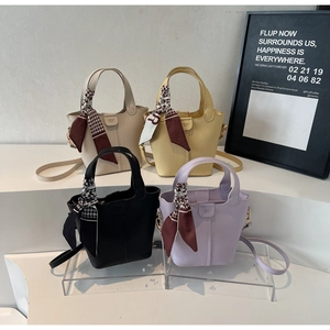 Detail of four colorful bucket bags with houndstooth silk scarves and detachable straps