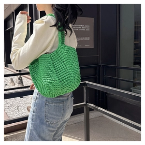 Detail of vivid green hand-woven tote bag showing intricate rope texture and hollow design