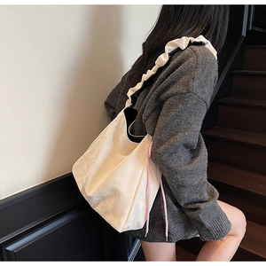 Détail de la bandoulière à volants et du cordon latéral sur le grand sac cabas plissé