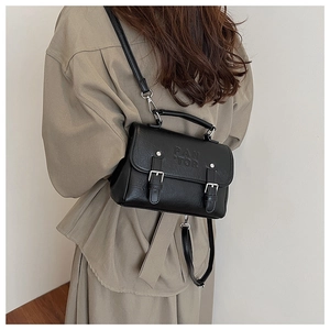 Detailed view of the black retro PU leather bag featuring PAN TOR embossed logo and buckles
