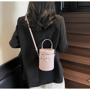 Rosa gesteppte Beuteltasche getragen von einem Model vor einem Vintage-Holzhintergrund