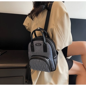 Detail view of fashion gray backpack with pleated design and black leather accents