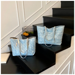 Close-up of light blue woven tote bags with textured fabric and metallic trim details
