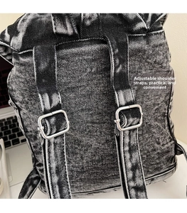 Detalle de correas ajustables de mochila de mezclilla con hebillas de plata en escritorio