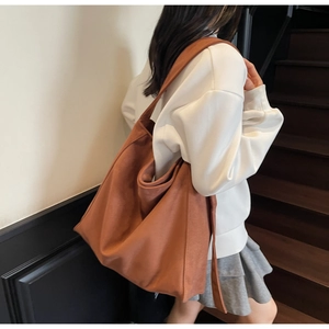 Grande borsa tote in tela marrone caramello indossata da una modella per uno stile casual