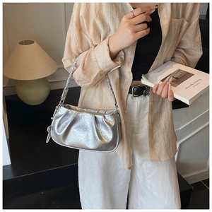 Sac nuage en cuir ciré argenté avec plis et poignée tressée porté par un mannequin