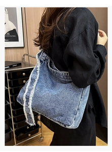 Vue détaillée du grand sac cabas en jean avec bords effilochés et denim bleu délavé