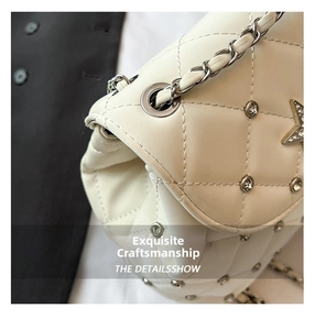 Close-up of white quilted leather texture with star studs and chain strap details
