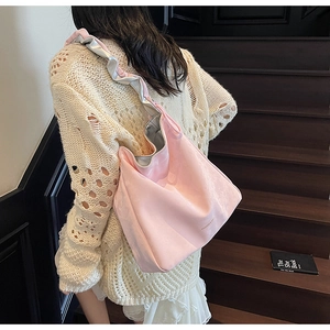 Detail of pink tote bag with silver ruffled shoulder strap and smooth leather texture