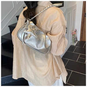 Détail du sac en cuir plissé argenté avec breloque étoile et bandoulière chaîne