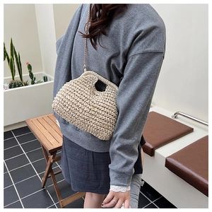 Détail du sac nuage en paille beige avec texture crochetée et fine bandoulière dorée